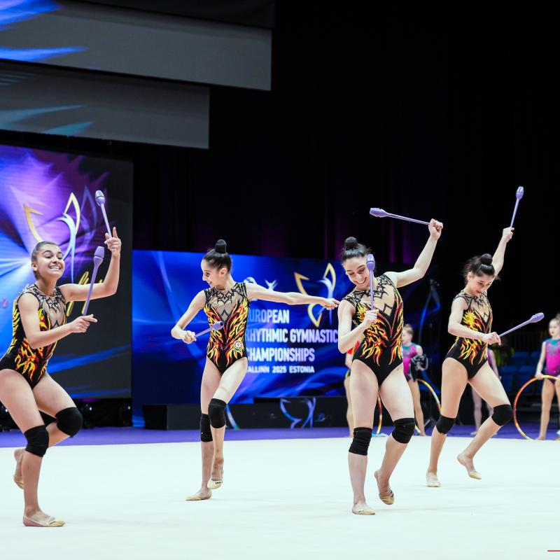 Group gymnasts with clubs